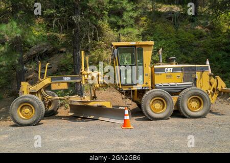 Une niveleuse Caterpillar 160H stationnée sur une route dans la forêt nationale de nez Perce, Idaho, États-Unis Banque D'Images