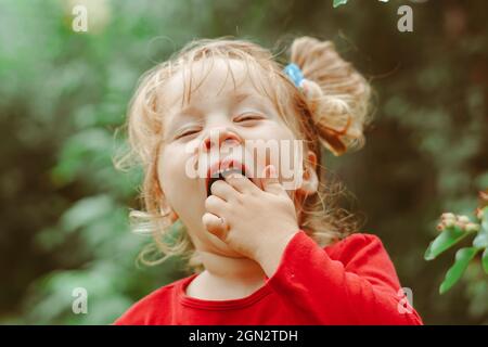 enfant dans le jardin avec baies Banque D'Images