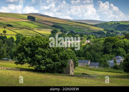 Vue sur le village de Hayfield à High Peak, Derbyshire.On peut voir la copse des arbres connus sous le nom de vingt arbres sur la colline éloignée. Banque D'Images