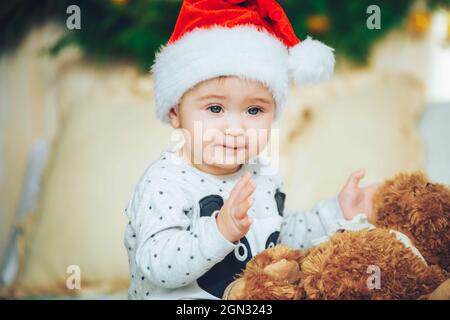 Portrait du beau petit garçon fête Noël. Les fêtes du nouvel an. Adorable enfant drôle en chapeau rouge de père Noël avec cadeau de Noël. Noël Banque D'Images