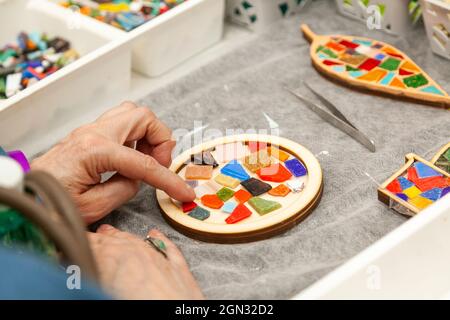 Master class sur la fabrication de panneaux de mosaïque. Gros plan des mains d'un étudiant d'une femme adulte qui organise une composition Banque D'Images