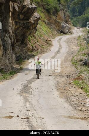 Bandipora, Jammu-et-Cachemire, Inde. 21 septembre 2021. Le 21 septembre 2021, un garçon fait une promenade à vélo le long d'une route de montagne isolée en hauteur dans l'Himalaya reliant Srinagar à Gilgit Bertistan, dans le district de Bandipora. Le Col de Razdan est le seul col de haute altitude entre Srinagar et Gurez, à une hauteur de 11 672 pieds au-dessus du niveau de la mer. La route qui traverse le col, appelée autoroute Bandipora-Gurez, relie plusieurs villages éloignés, y compris ceux situés près de la LOC, à Bandipora et Srinagar. Crédit: Adil Abbas/ZUMA Wire/Alay Live News Banque D'Images