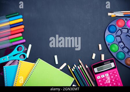 Éducation, concept de retour à l'école. Fournitures scolaires sur tableau noir avec espace de copie. Banque D'Images