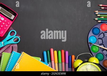 Éducation, concept de retour à l'école. Fournitures scolaires sur tableau noir avec espace de copie. Banque D'Images