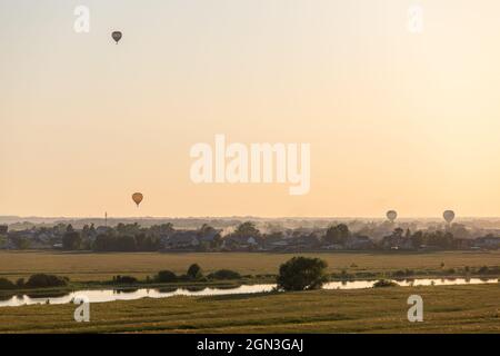 Des ballons d'air chaud colorés s'envolent dans le ciel au crépuscule ou à l'aube. Survolez le brouillard au lever ou au coucher du soleil avec un magnifique fond de ciel. Voyages et tourisme Banque D'Images