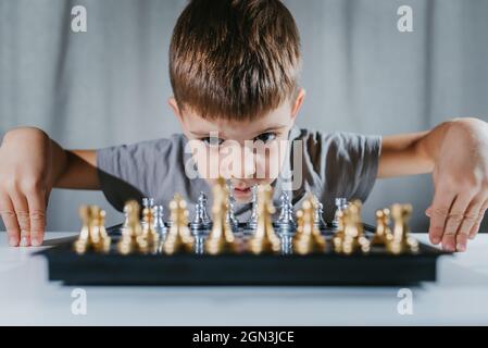 L'enfant apprend à jouer aux échecs à la maison Banque D'Images