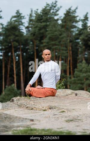 sweat-shirt blanc bouddhic qui vous attend tout en pratiquant la pose de lotus sur une falaise rocheuse Banque D'Images