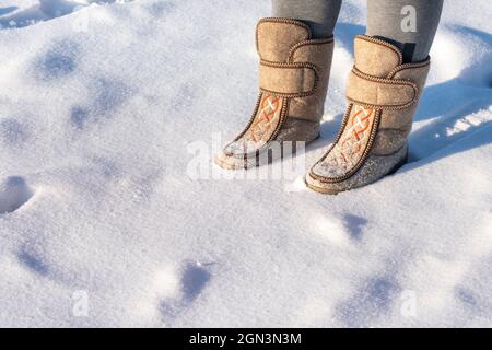 Gros plan d'un homme dans des bottes en feutre debout dans la neige. Banque D'Images