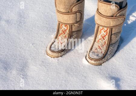 Gros plan d'un homme dans des bottes en feutre debout dans la neige. Banque D'Images