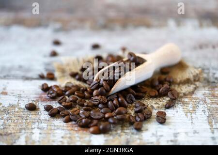 Grains de café dans une spatule en bois.Grains de café torréfiés. Banque D'Images