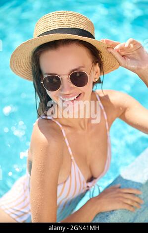 Une photo d'une jolie jeune femme qui passe du temps dans une piscine Banque D'Images