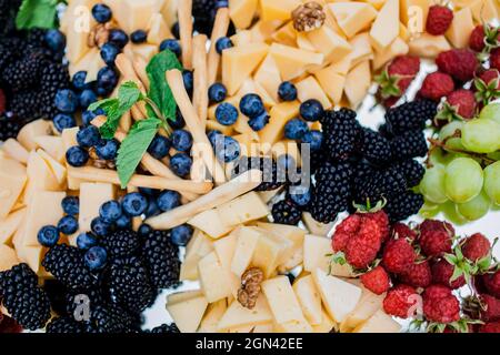 Assiette de fromages servie avec des raisins, de la confiture, des figues, des craquelins et des noix. Banque D'Images