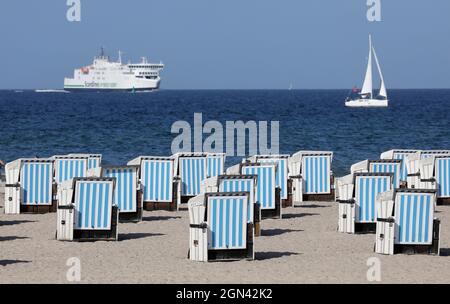 Mecklembourg-Poméranie occidentale, 22 septembre 2021, 22 septembre 2021, Mecklembourg-Poméranie occidentale, Warnemünde: Un ferry Scandilines et un voilier sont sur la mer Baltique, la plupart des chaises de plage sont vides. Le temps ensoleillé a remplacé les nuages et la pluie. Photo: Bernd Wüstneck/dpa-Zentralbild/dpa Banque D'Images