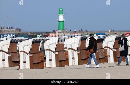 Mecklembourg-Poméranie occidentale, 22 septembre 2021, 22 septembre 2021, Mecklembourg-Poméranie occidentale, Warnemünde: Les randonneurs profitent du soleil à la mer Baltique, la plupart des chaises de plage sont vides. Le temps ensoleillé a remplacé les nuages et la pluie. Photo: Bernd Wüstneck/dpa-Zentralbild/dpa Banque D'Images