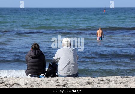 22 septembre 2021, Mecklembourg-Poméranie occidentale, Warnemünde : les visiteurs profitent du soleil de la mer Baltique. Le temps ensoleillé a remplacé les nuages et la pluie. Photo: Bernd Wüstneck/dpa-Zentralbild/dpa Banque D'Images