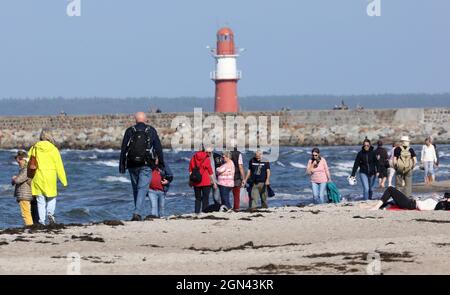 22 septembre 2021, Mecklembourg-Poméranie occidentale, Warnemünde: Les randonneurs profitent du soleil sur la mer Baltique pendant qu'un ferry Scandilines arrive. Le temps ensoleillé a remplacé les nuages et la pluie. Photo: Bernd Wüstneck/dpa-Zentralbild/dpa Banque D'Images