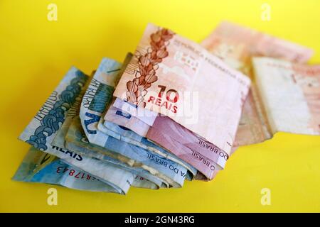 argent du brésil empilé sur la surface jaune - plusieurs vrais billets brésiliens Banque D'Images