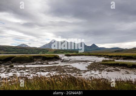 Les sommets déchiquetés de Ben Loyal s'élèvent au-delà de l'estran boueux intertidal du Kyle de la langue près du NC500, dans le nord de l'Écosse, lors d'une journée nuageux. Banque D'Images
