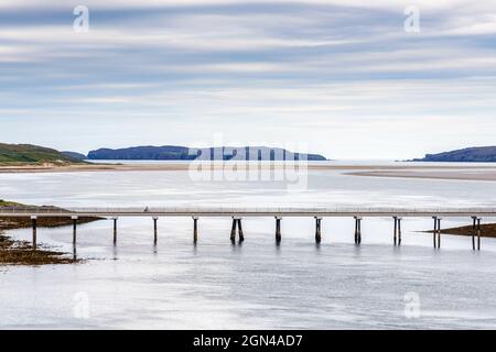 Un cycliste solitaire traverse le pont Kyle of Tongue sur l'A838, une partie de l'A500 en Écosse, avec Tongue Bay et l'île Eilean Nan Ron au-delà. Banque D'Images