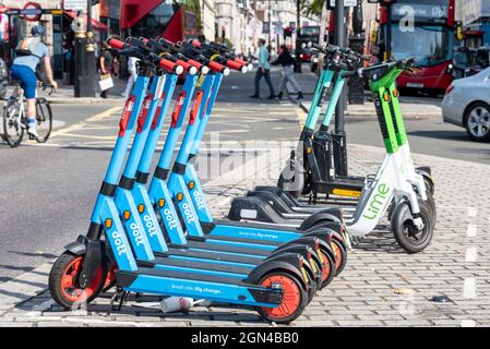 Lime et Dott e scooters à louer à Londres, Royaume-Uni, avec bus et voiture. Cycliste et personnes marchant. Ville animée avec scooters électriques dans la rue Banque D'Images