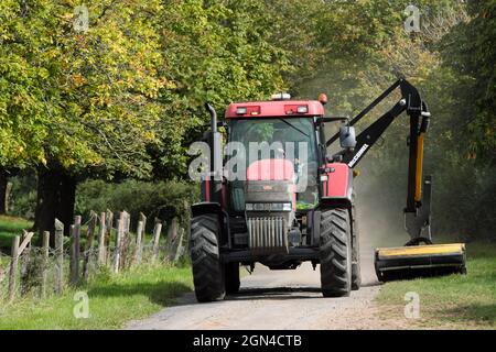 Agriculteur utilisant un tracteur pour couper l'herbe le long d'une voie de campagne dans le Herefordshire septembre 2021 Royaume-Uni Banque D'Images