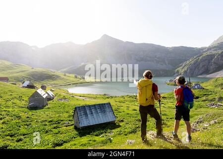 Mère et fils randonneurs debout près des maisons traditionnelles de berger au lac kapetanovo, lac du capitaine, dans les montagnes au-dessus de niksic montenegro Banque D'Images