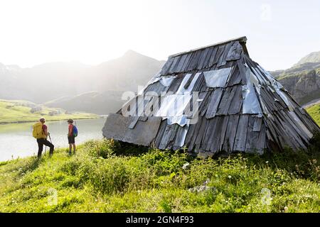 Mère et fils randonneurs debout près de la cabane traditionnelle en bois de berger au lac kapetanovo, lac du capitaine, dans les montagnes au-dessus de niksic montenegro Banque D'Images