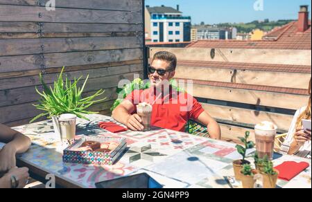 Homme prenant un verre sur une terrasse Banque D'Images