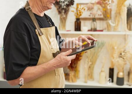 Photo rognée d'un homme moderne qui fait l'inventaire des stocks tout en travaillant dans le magasin de fleuristes, l'espace de copie Banque D'Images