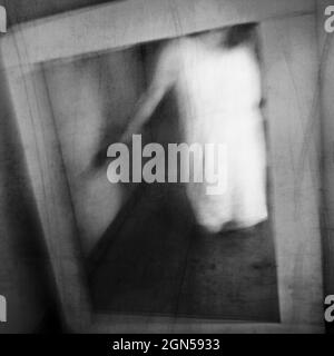 Un fantôme apparaît dans un vieux miroir vintage. Apparition du fantôme. Exposition longue. Banque D'Images