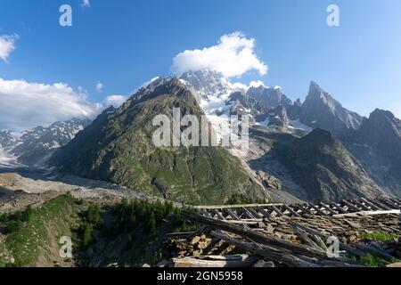 Toit réduit de la hutte abandonnée dans les montagnes. Poutres de bois laissées sur des pierres. Montagnes européennes avec glacier et neige Banque D'Images