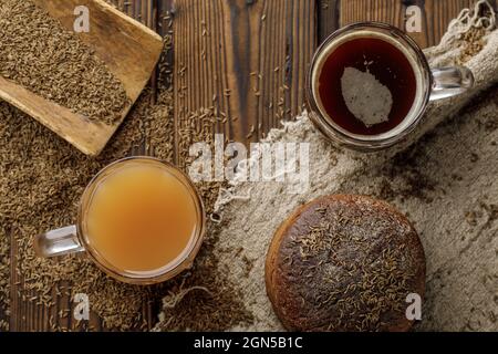 Verre transparent tasse de thym et de pomme bio détox boisson et traditionnelle kvass bière mug avec pain de seigle sur table en bois de style rustique. Thym comme mer Banque D'Images