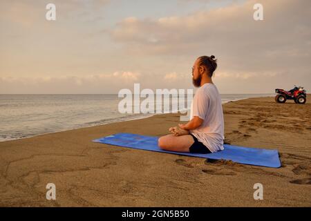 Man meditating at beach Banque D'Images