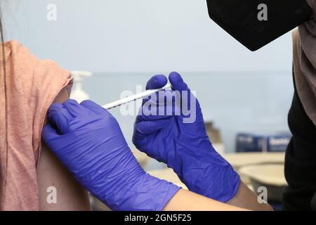 Londres, Royaume-Uni. 10 septembre 2021. Un membre du personnel du NHS administre le vaccin Covid-19 de Pfizer à une femme dans un centre de vaccination. Selon le ministère de la Santé et des Affaires sociales, le Royaume-Uni enverra un million de doses du vaccin contre le coronavirus Pfizer en Corée du Sud. En retour, la Corée du Sud enverra le même « volume global de doses » avant la fin de 2022. Crédit : SOPA Images Limited/Alamy Live News Banque D'Images