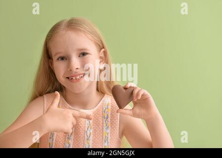 Petite fille mignonne avec du chocolat doux sur fond de couleur Banque D'Images