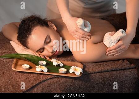 Belle jeune femme afro-américaine recevant un massage dans le salon de spa Banque D'Images