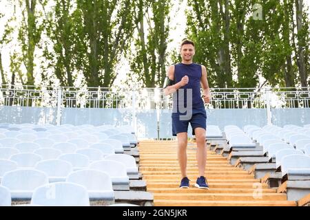 Jeune homme sportif en bas au stade Banque D'Images