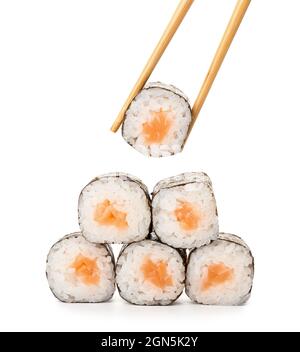 Des baguettes qui prennent un délicieux rouleau maki avec du saumon sur fond blanc Banque D'Images