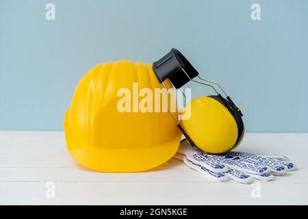 Casque HardHat avec protections auditives et gants sur fond de couleur Banque D'Images