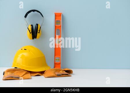 Casque HardHat avec protections auditives et fournitures de construction sur fond de couleur Banque D'Images