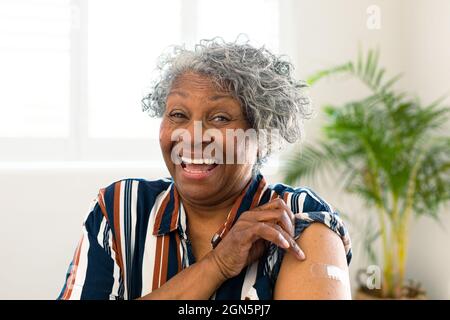 Bonne femme afro-américaine senior avec du plâtre sur le bras, regardant la caméra après la vaccination Banque D'Images