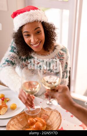 Bonne femme afro-américaine qui fait du pain grillé à la table de noël Banque D'Images