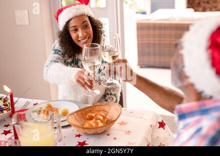 Bonne fille adulte afro-américaine et père senior pour faire des toasts à la table de noël Banque D'Images