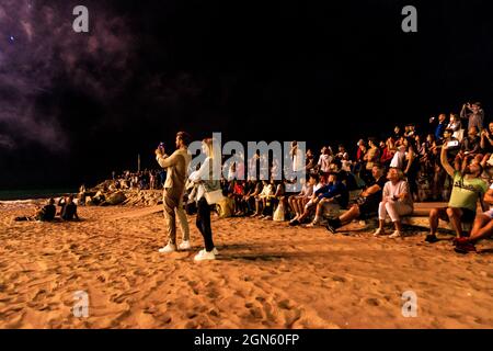 Sitges, Espagne. 22 septembre 2021. Les spectateurs se rassemblent à un brise-lames pour suivre l'exposition traditionnelle de feux d'artifice à l'église 'de Bartolomeu' pendant la petite 'Festa Major' de Sitges, 'Santa Tecla'. Cette année, l'édition corona a pris une forme très réduite laissant la plage presque vide. Credit: Matthias Oesterle/Alamy Live News Banque D'Images