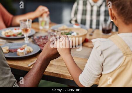 Gros plan des enfants qui tiennent les mains à l'extérieur pour dîner en famille et prier, copier l'espace Banque D'Images