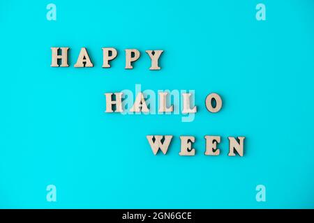 Joyeux halloween texte fait de lettres en bois sur fond bleu. Carte de vœux Banque D'Images