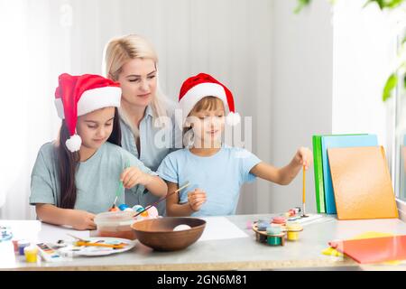 La mère et la fille peignant des ornements de Noël Banque D'Images