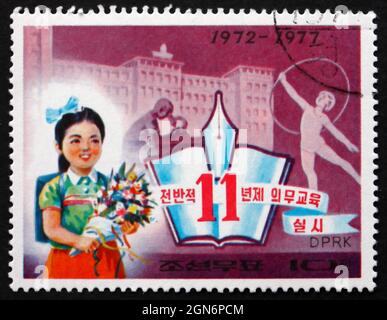 CORÉE DU NORD - VERS 1977 : un timbre imprimé en Corée du Nord montre une écolière, 11 ans d'éducation obligatoire, 5e anniversaire, vers 1977 Banque D'Images