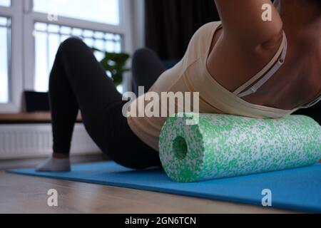 Femme faisant des exercices de rouleau de mousse pour soulager la douleur de dos gros plan Banque D'Images