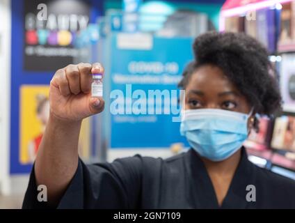 USAGE ÉDITORIAL SEULEMENT Siphiwe Chungu, directeur de pharmacie chez Supermed, Merrion Centre à Leeds, avec un flacon de Pfizer qui sera administré comme premier vaccin de rappel Covid-19 dans la rue haute au Royaume-Uni. Date de la photo : jeudi 23 septembre 2021. Banque D'Images